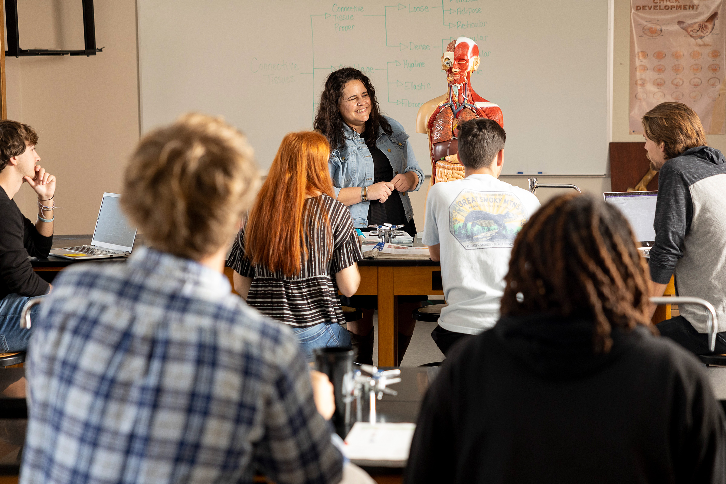 Professor smiling while teaching students at Greensboro College