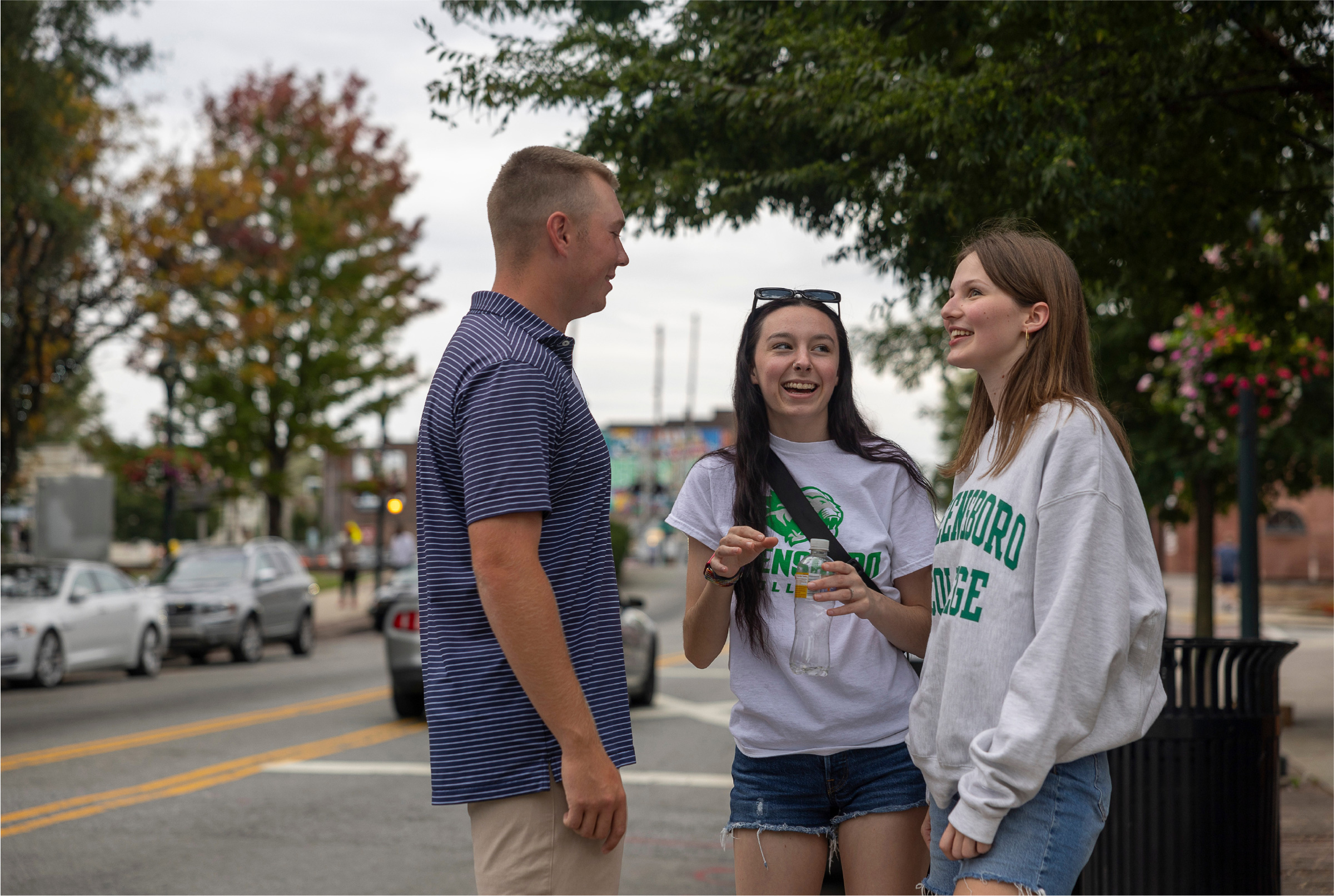 Excited Greensboro College students chatting in a parking lot