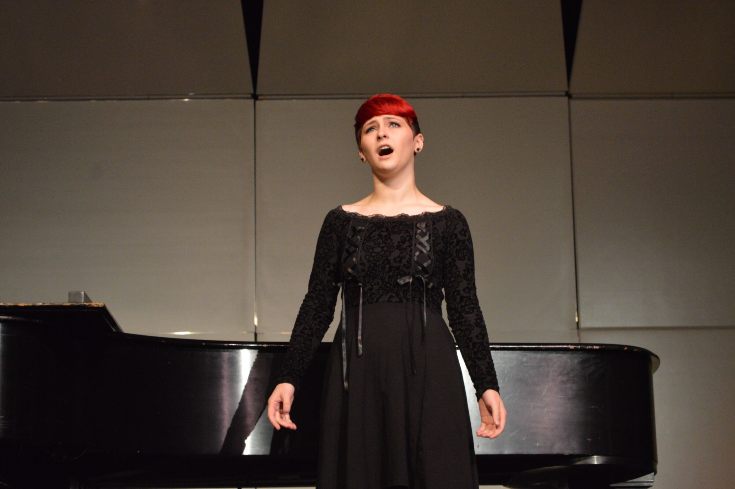 Greensboro College student on stage singing.